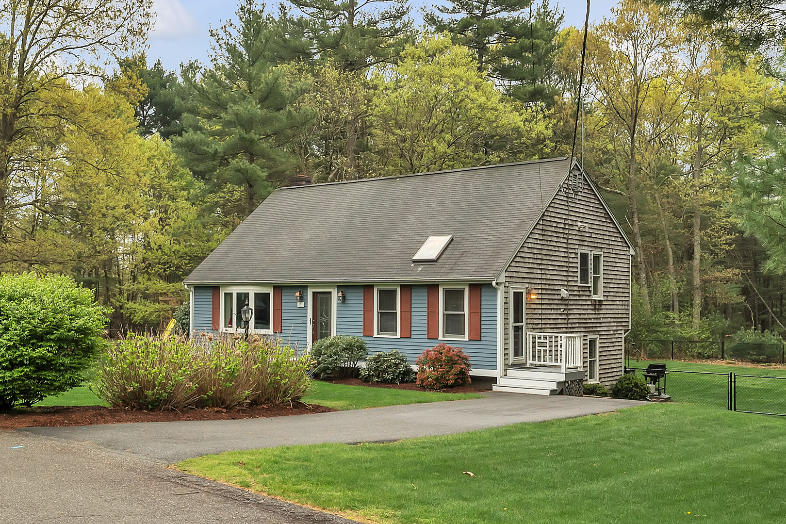 Single-story house featuring a blue and brown exterior with a sloped roof and front porch.